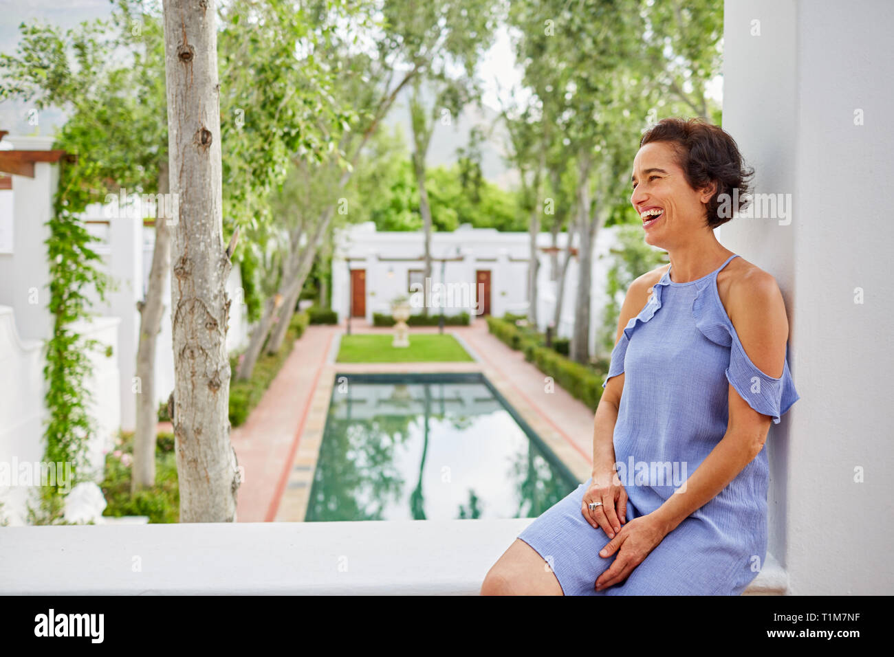 Laughing, carefree woman on hotel balcony Stock Photo