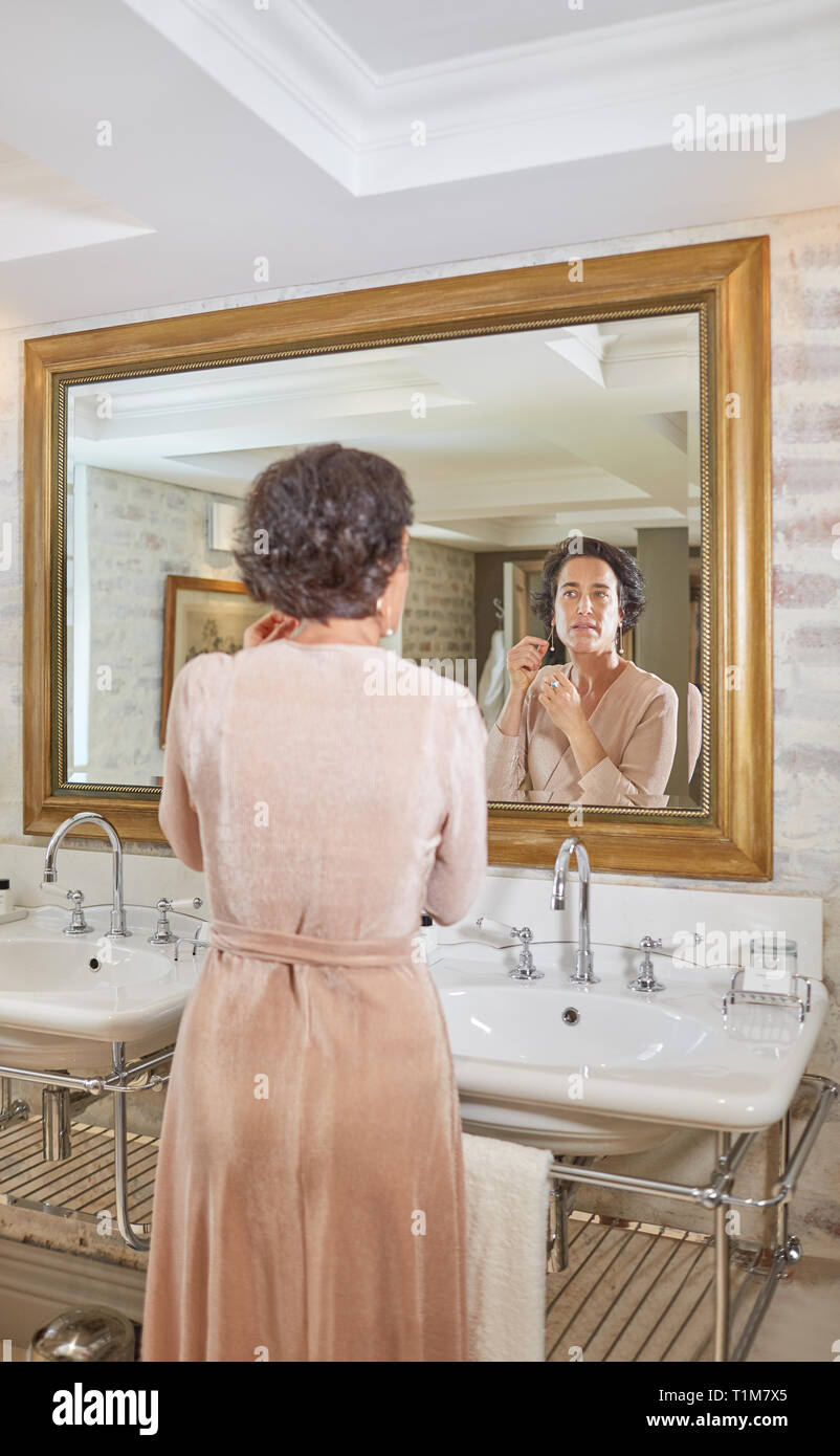 Woman getting ready at hotel bathroom mirror Stock Photo