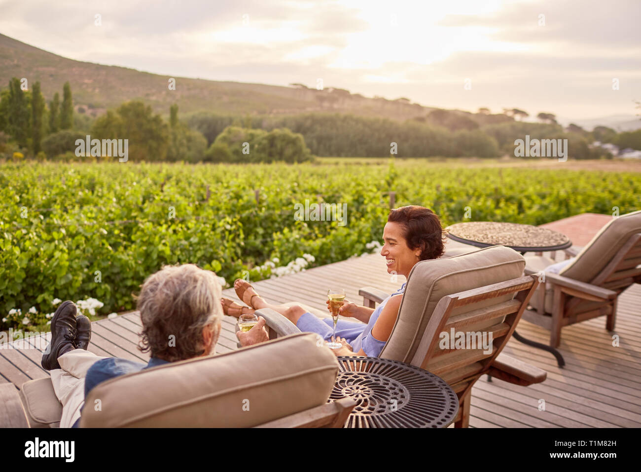 Couple relaxing, drinking wine on idyllic, rural resort patio Stock Photo