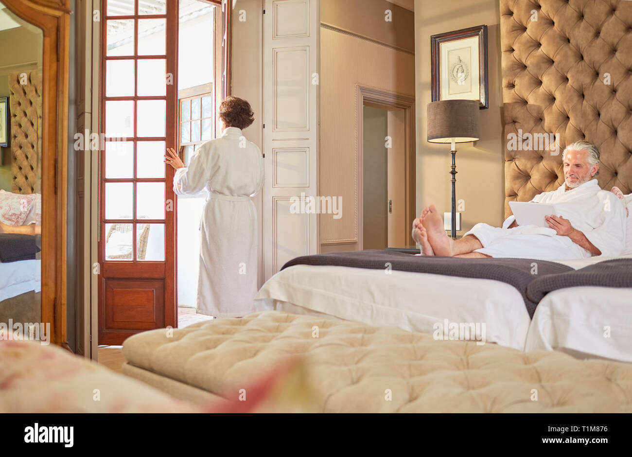 Couple in bathrobes relaxing in hotel room Stock Photo