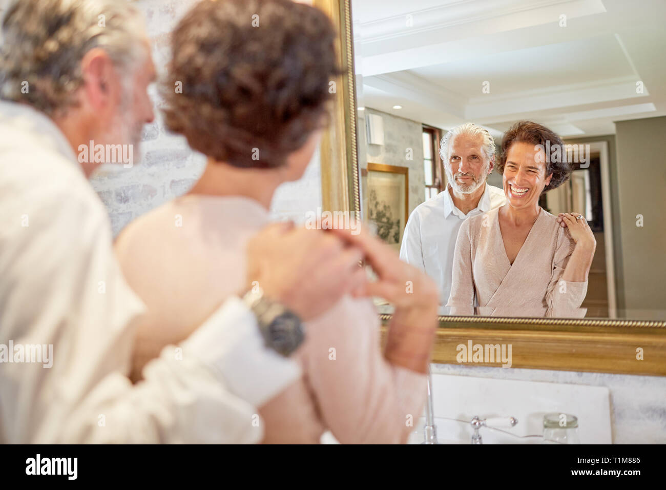 Happy mature couple at hotel bathroom mirror Stock Photo