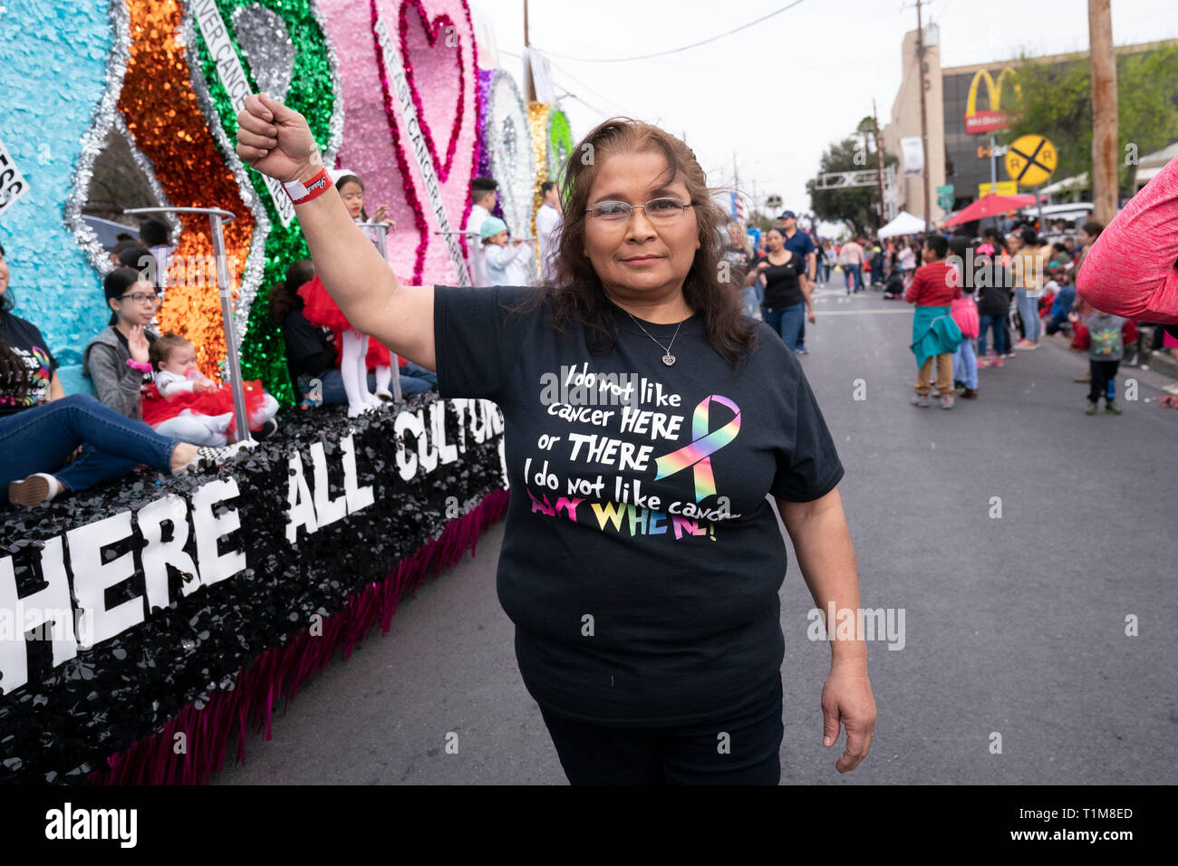 Hispanic woman wears cancer-awareness tee shirt based on lines from Dr. Seuss children's book 'Green Eggs and Ham' at parade in downtown Laredo, Texas. Stock Photo