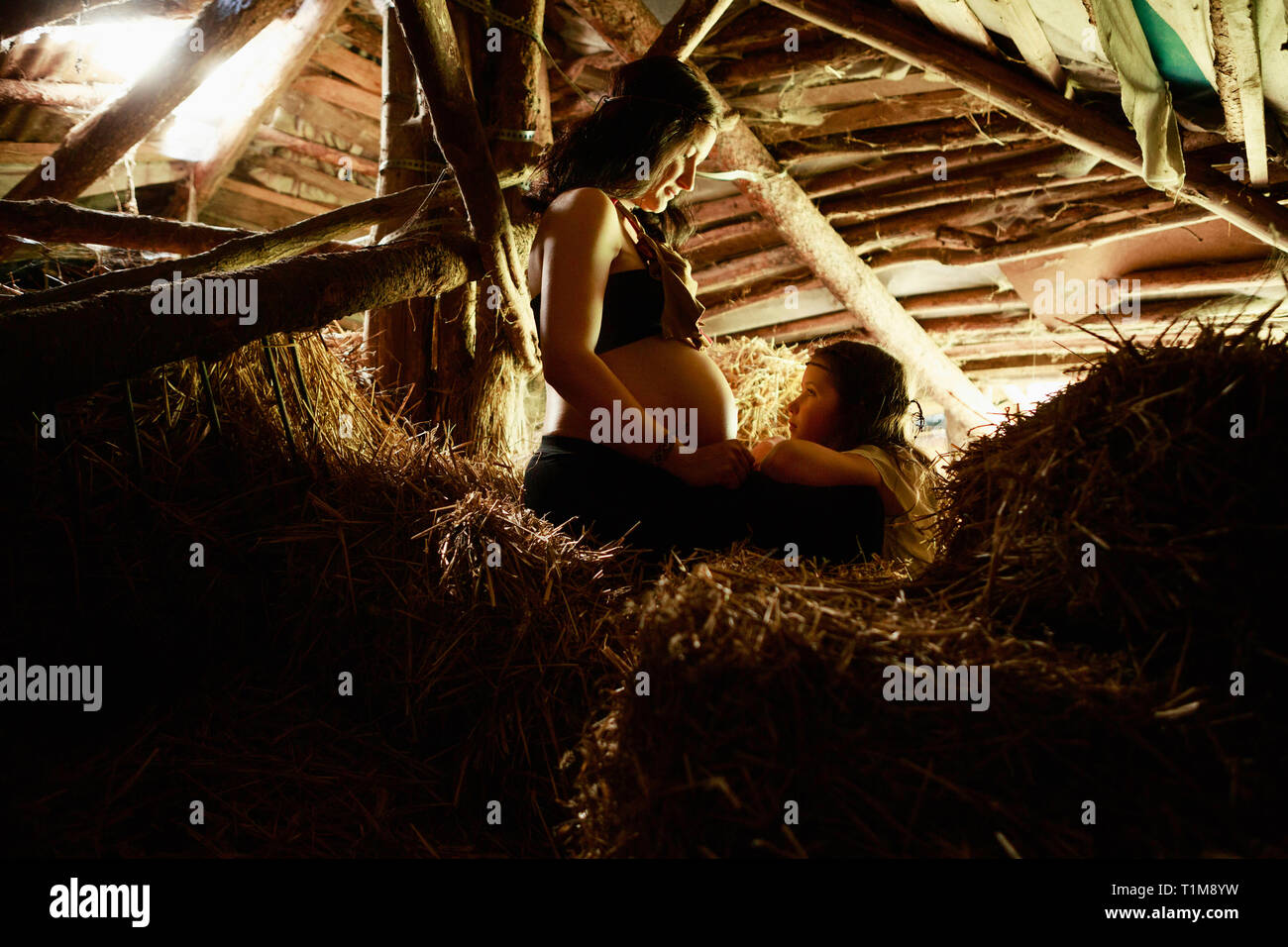Pregnant mother and daughter in rural hay loft Stock Photo - Alamy