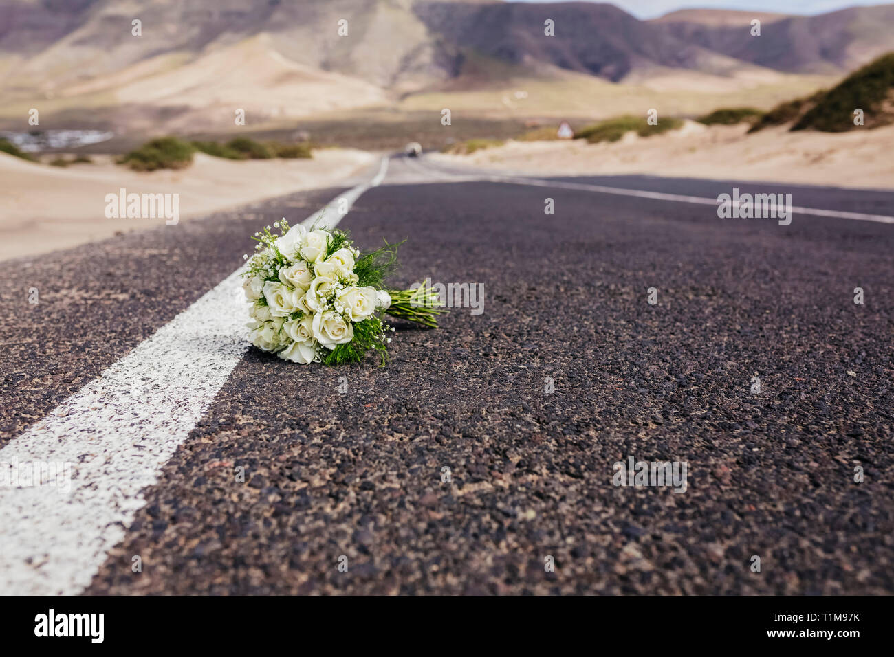 Bridal bouquet with roses laying on remote road Stock Photo