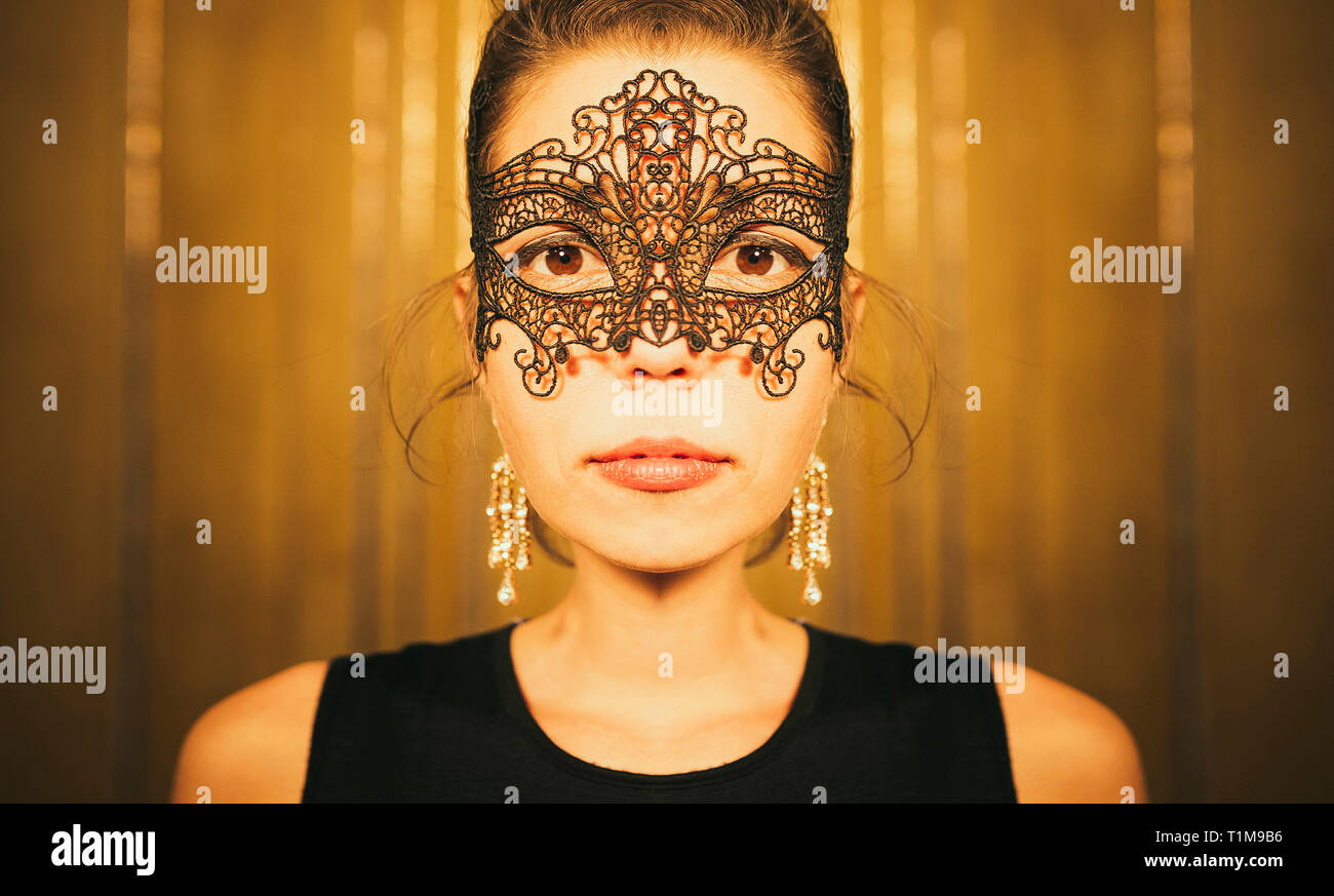 Portrait serious, beautiful woman in masquerade mask Stock Photo