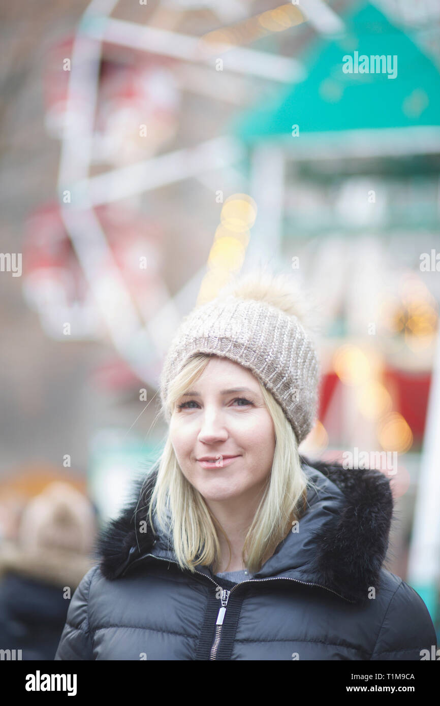 Portrait confident woman in warm clothing at carnival Stock Photo