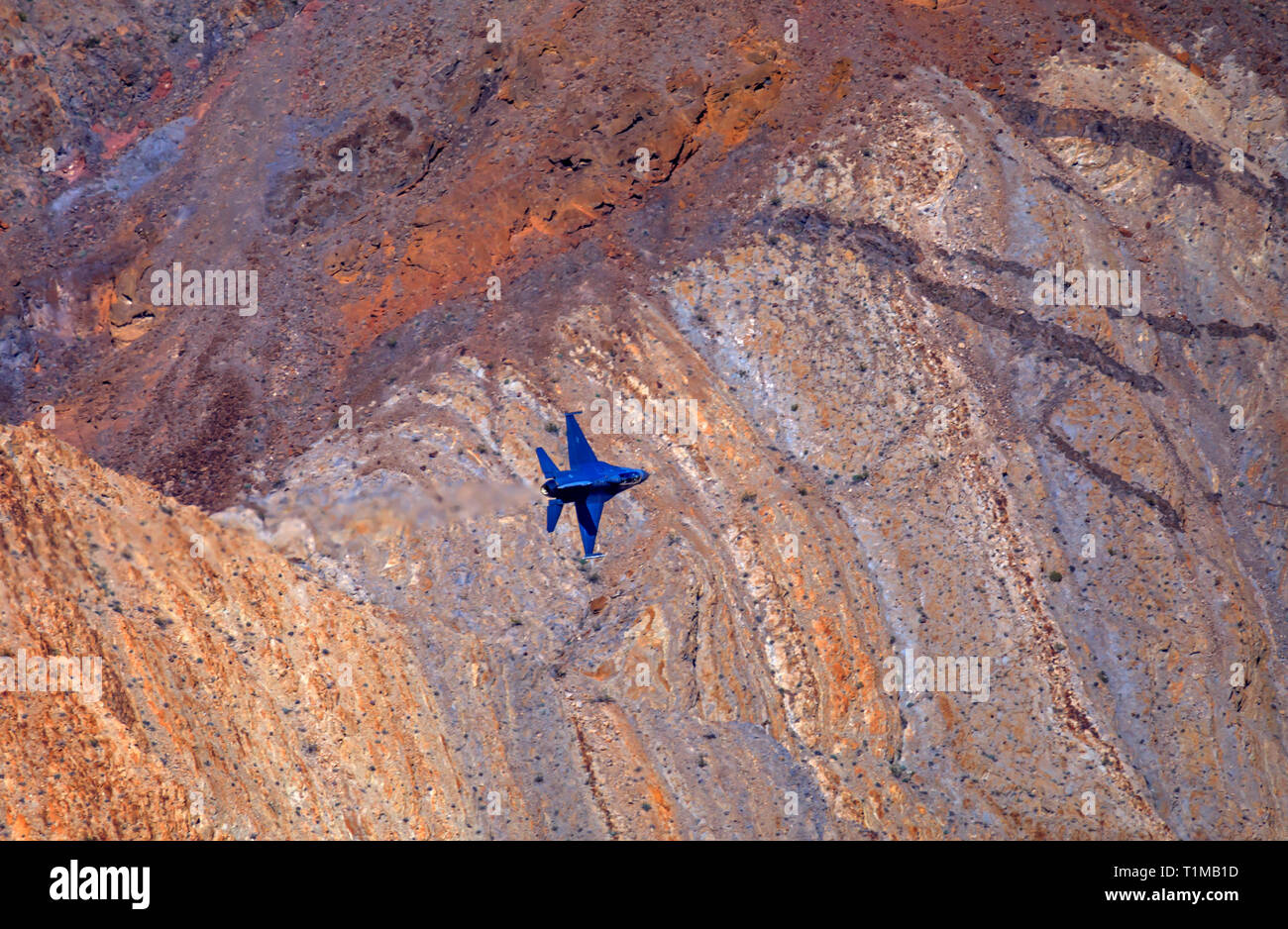 A General Dynamics F-16 Fighting Falcon flies with wings vertical through Rainbow/Star Wars Canyon in Death Valley National Park, California, USA. Stock Photo