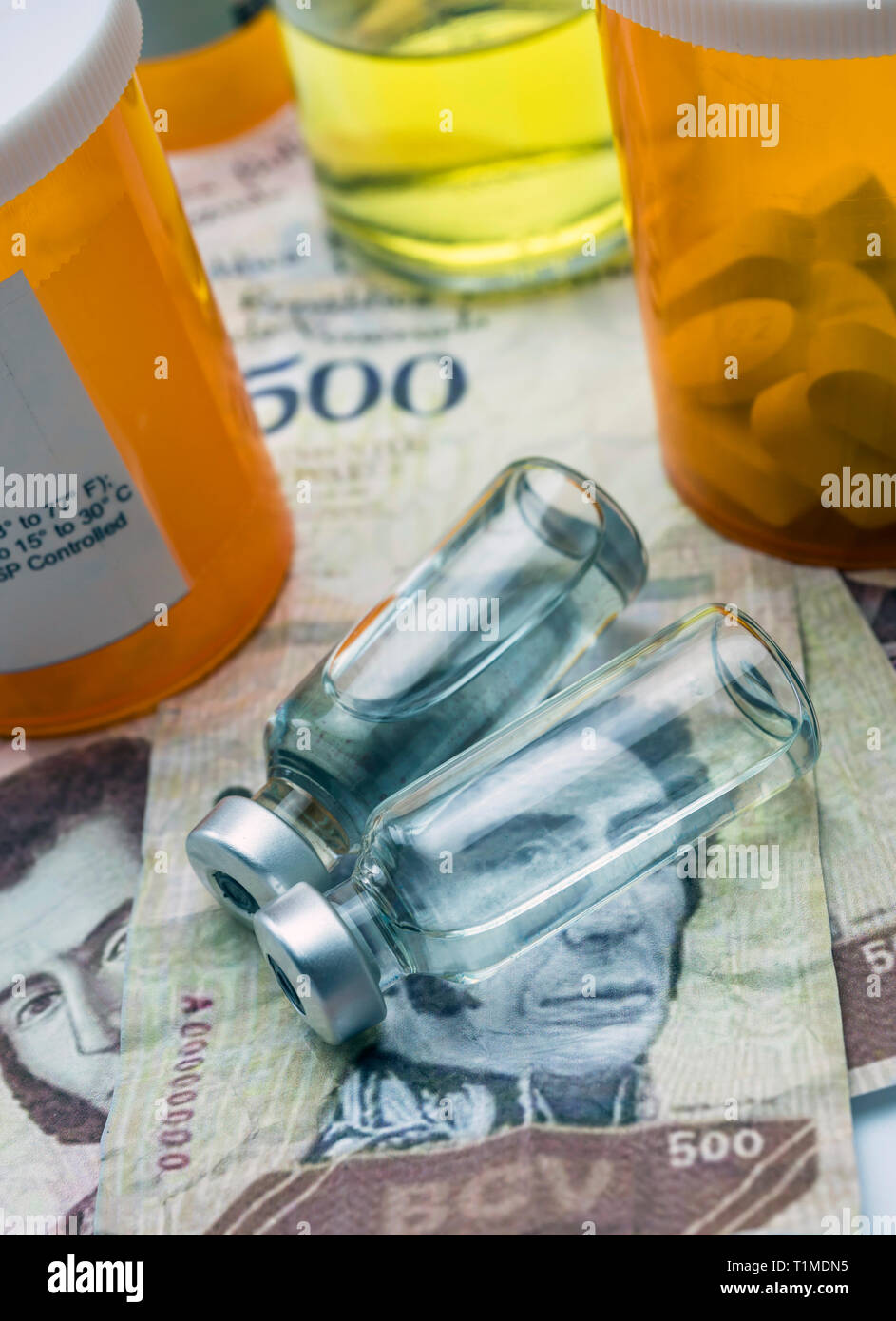 Vials with medication on banknotes Bolivarian, shady deal of medicines in full crisis of Latin American country, conceptual image Stock Photo