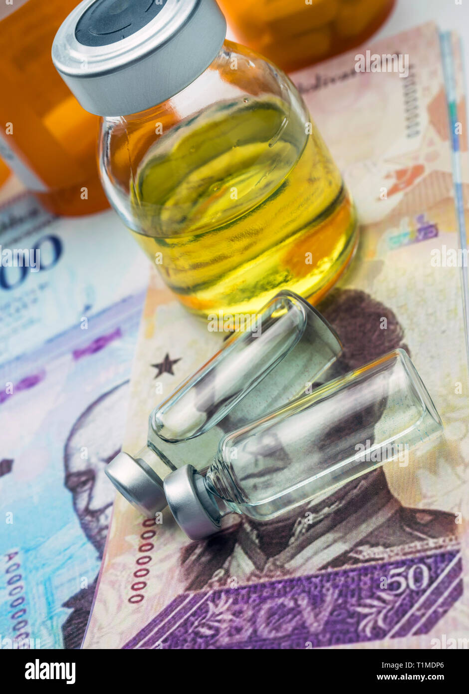 Vials with medication on banknotes Bolivarian, shady deal of medicines in full crisis of Latin American country, conceptual image Stock Photo