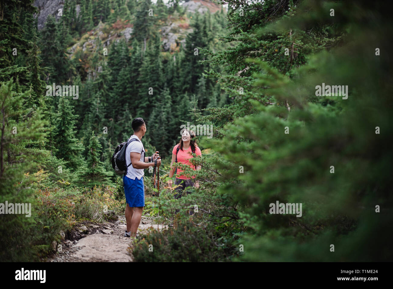 Couple hiking on remote trail in woods Stock Photo