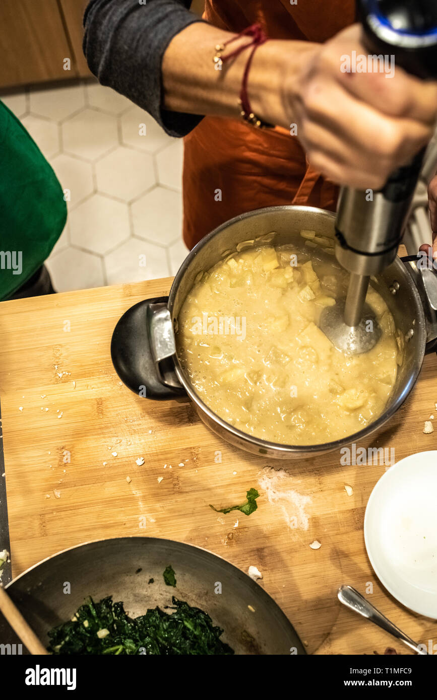 Woman using a blender during the preparation of a vegan dish in a ...