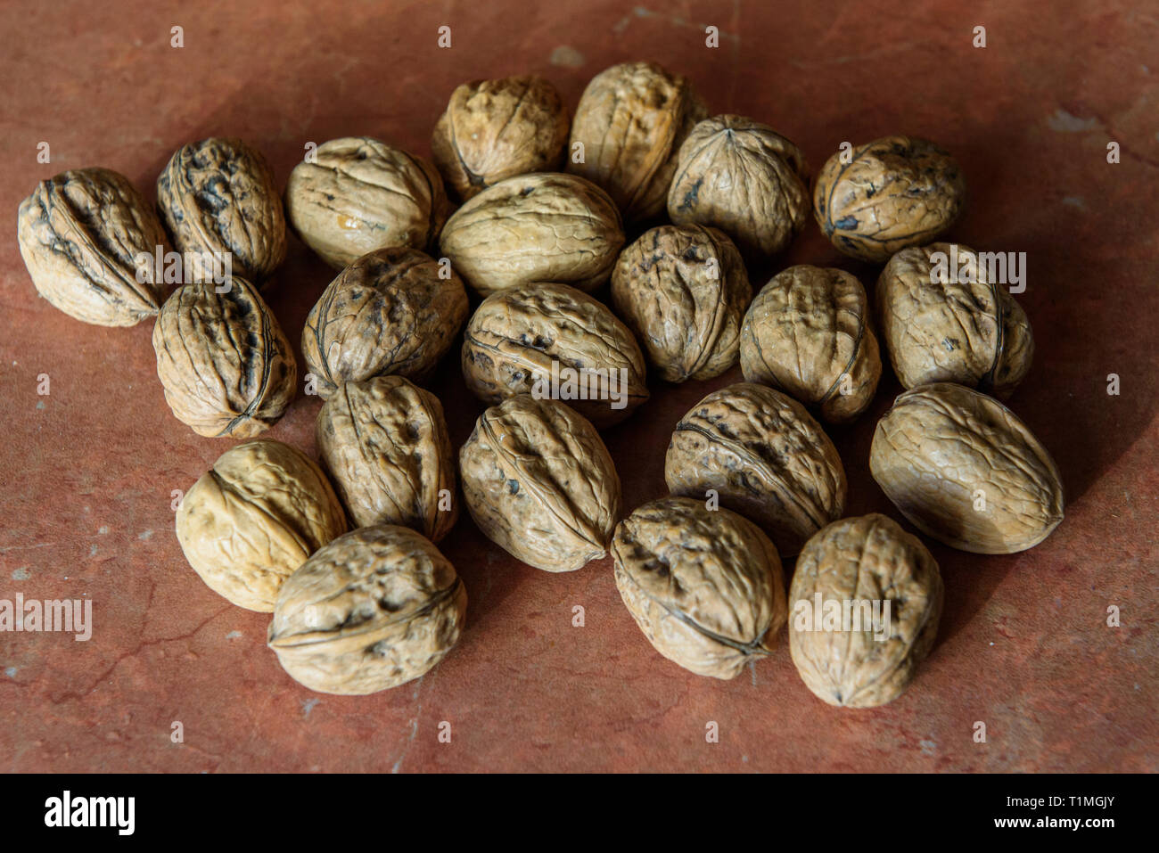 Dry walnuts (Juglans) in their shells. It contains a lot of manganese, magnesium, phosphorus and Vitamin B6. Walnuts contains also other minerals and  Stock Photo