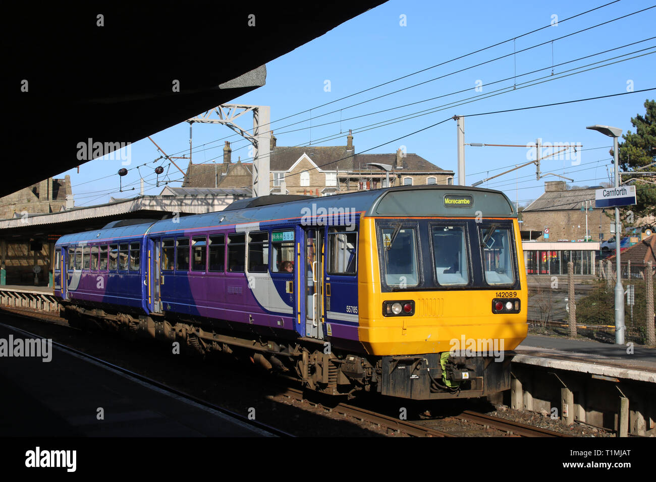 Class 142 Pacer two car diesel multiple unit in Northern livery leaving platform 1 Carnforth station with Leeds to Morecambe train on 25th March 2019. Stock Photo