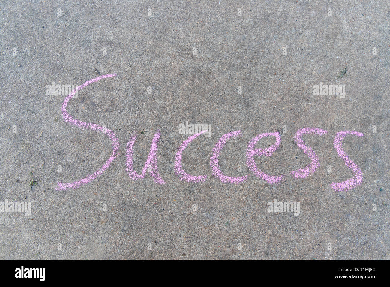 The words SUCCESS written with sidewalk chalk on concrete Stock Photo