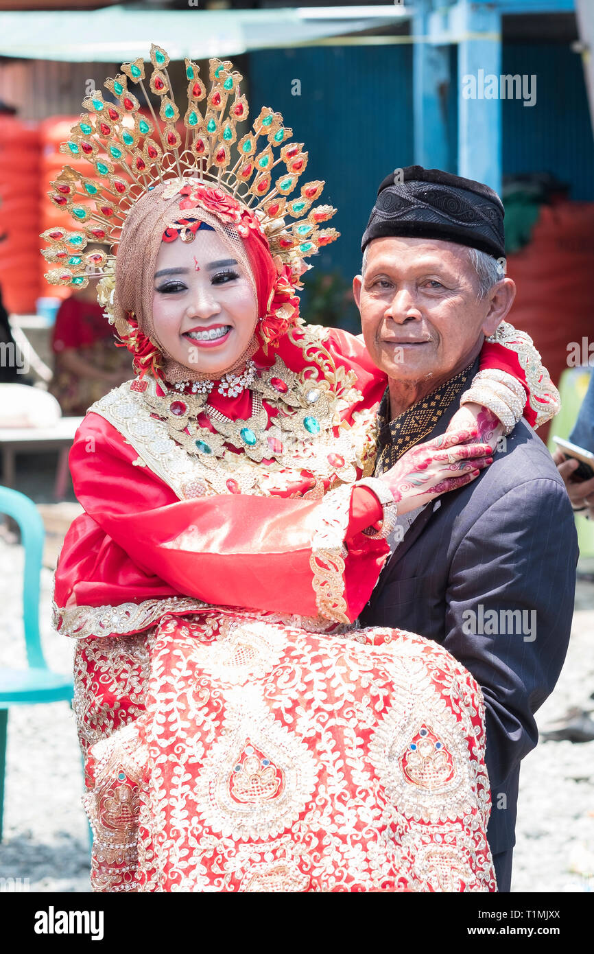 A father and his newly married daughter wearing a traditional Sulawesi wedding dress, Sulawesi, Indonesia Stock Photo