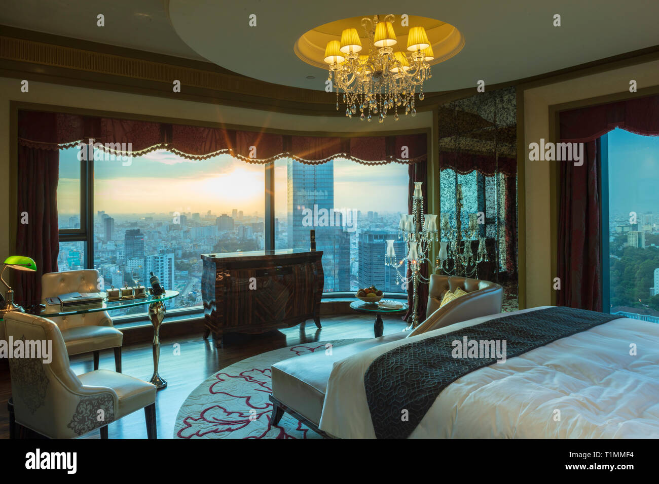 A bedroom in the Reverie Saigon hotel showing the city view from the bed, Ho Chi Minh City, Vietnam Stock Photo