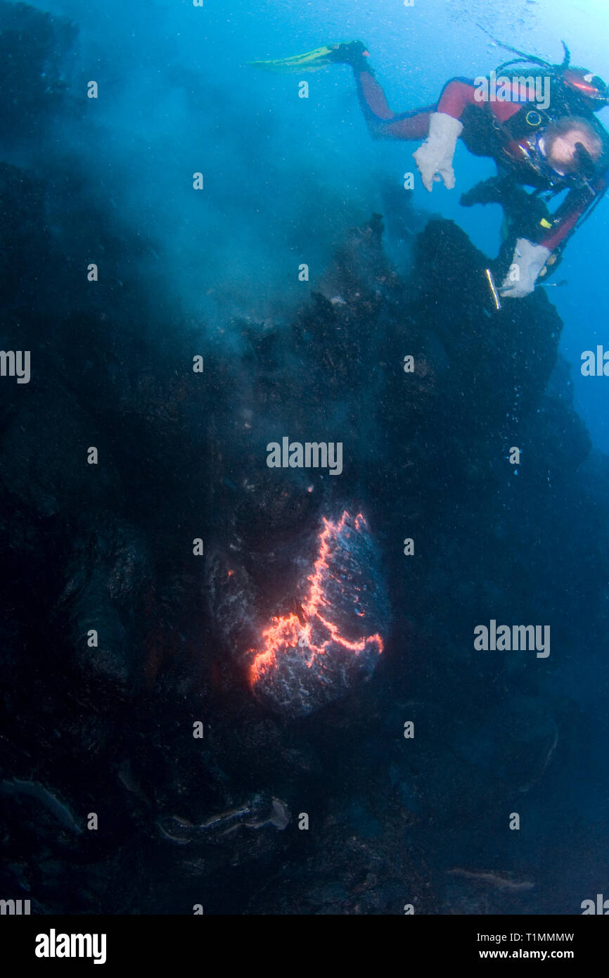 diver Bud Turpin observes pillow lava erupting underwater at ocean entry from Kilauea Volcano, Hawaii Island ( the Big Island ) Hawaii U.S.A. Stock Photo