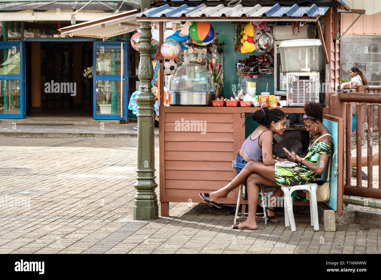 Port Louis, Mauritius - January 29, 2019: Two women talking sitting next to their stall store at the Central Market in Port Louis, Mauritius. Stock Photo