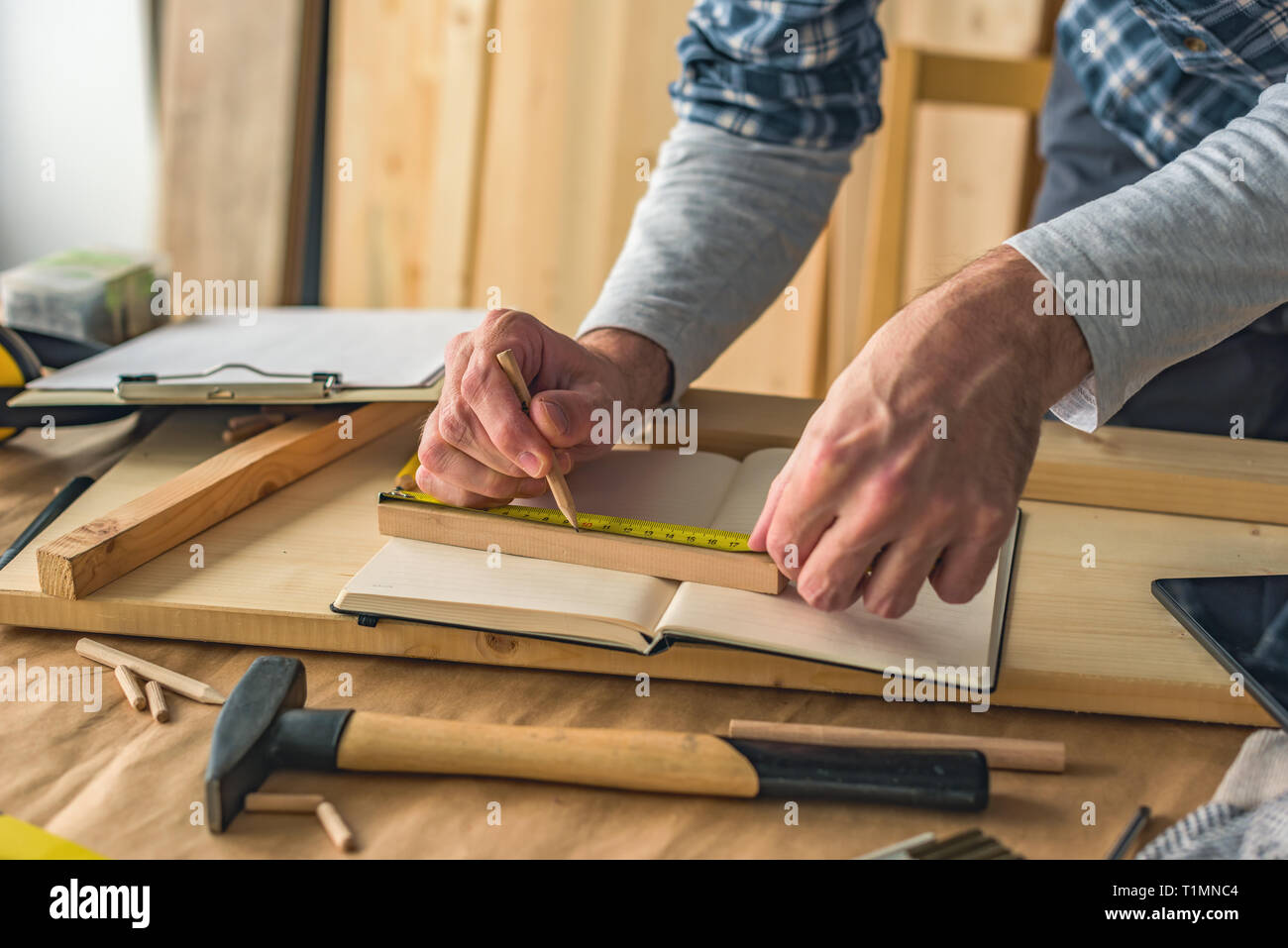 Carpenter making wooden picture frame in small business woodwork workshop, close up of hands Stock Photo