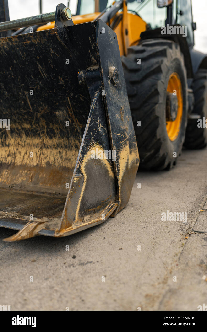 Construction vehicle with loader on building site, industrial heavy machinery Stock Photo