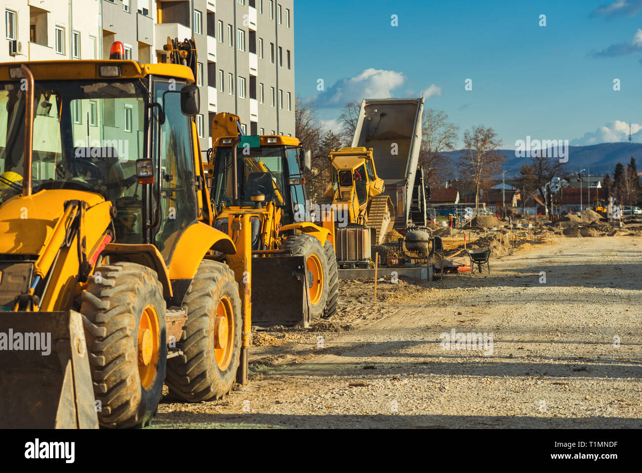 Construction vehicle with loader on building site, industrial heavy machinery Stock Photo