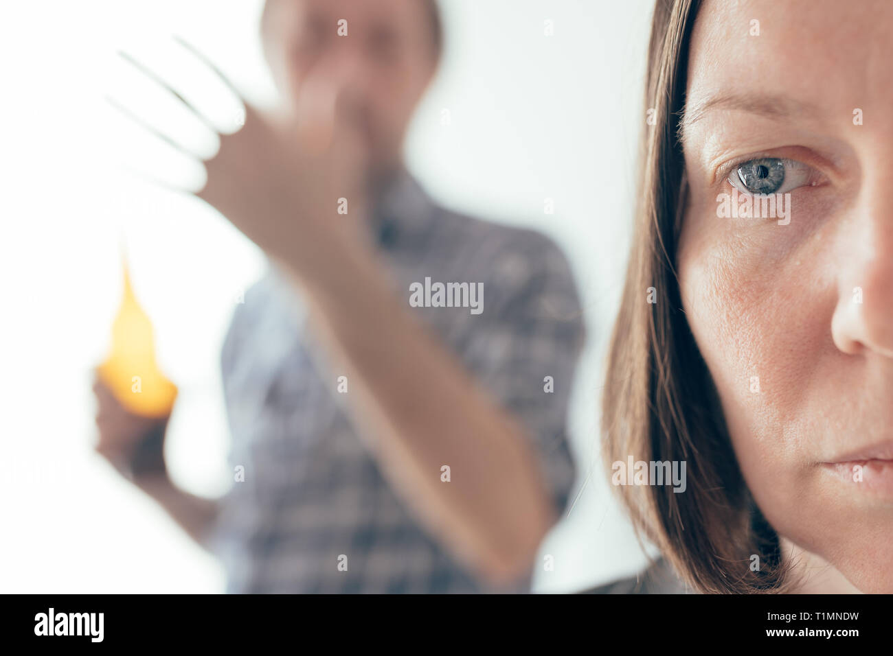 Drunk man drinking beer and arguing with his wife at home, adult caucasian couple in domestic dispute concept yelling at each other. Stock Photo