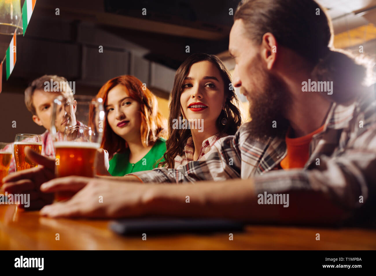 Girlfriend with red lips looking at her bearded man in the bar Stock Photo