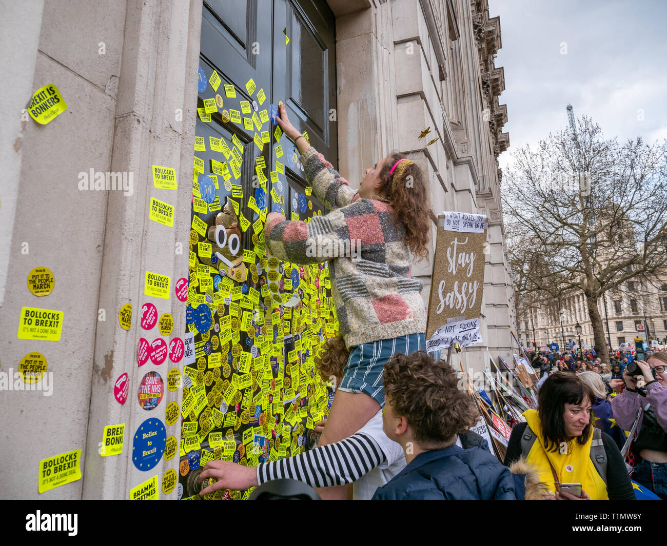 Demonstrators putting anti Brexit stickers on door of Cabinet Office building during the People's Vote march, 23 March 2019, Whitehall, London, UK Stock Photo