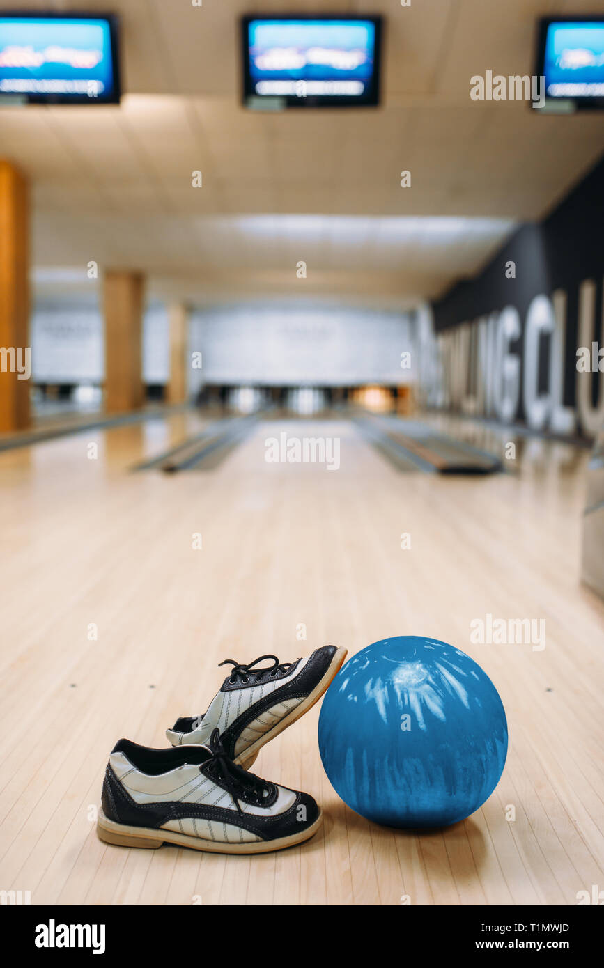 Bowling ball and house shoes on wooden floor Stock Photo