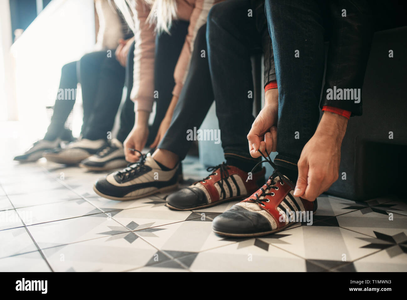 Bowling players ties shoelaces on house shoes Stock Photo