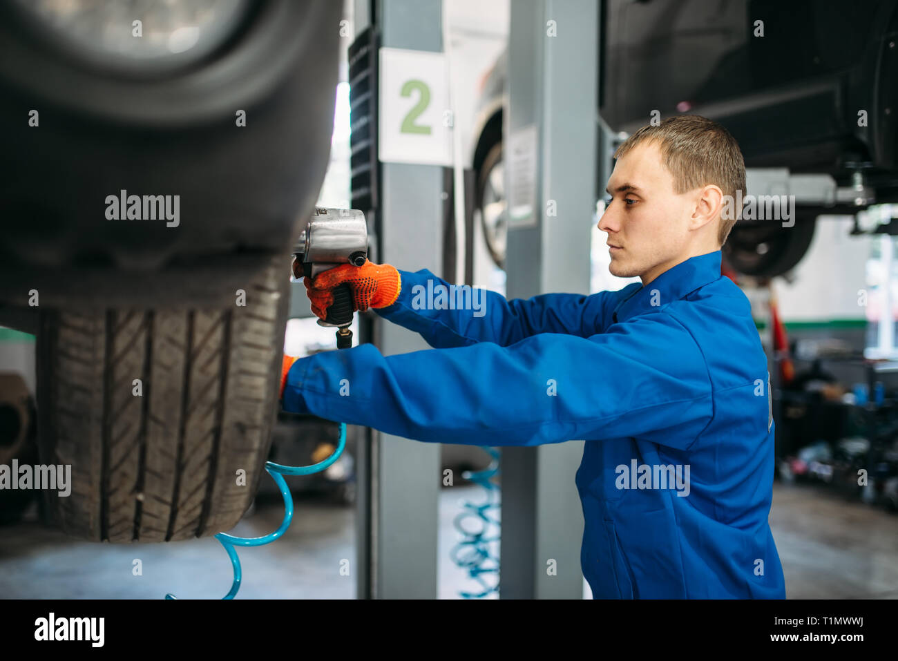 Mechanic unscrews the wheel with pneumatic wrench Stock Photo Alamy