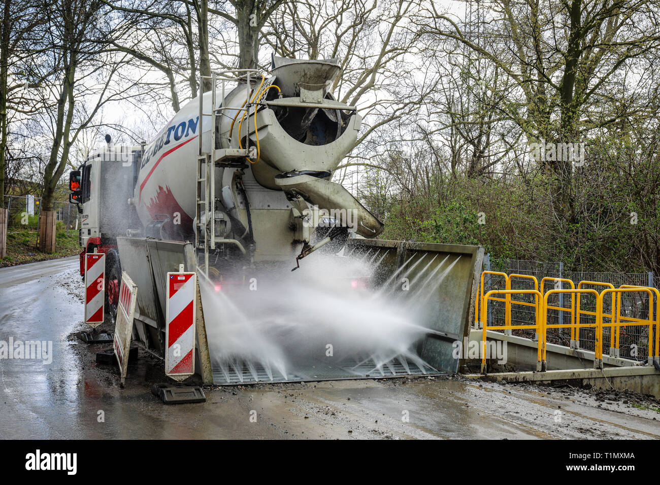 Essen, North Rhine-Westphalia, Germany - A construction site vehicle, here a concrete mixer, drives through a truck wash at a construction site exit.  Stock Photo