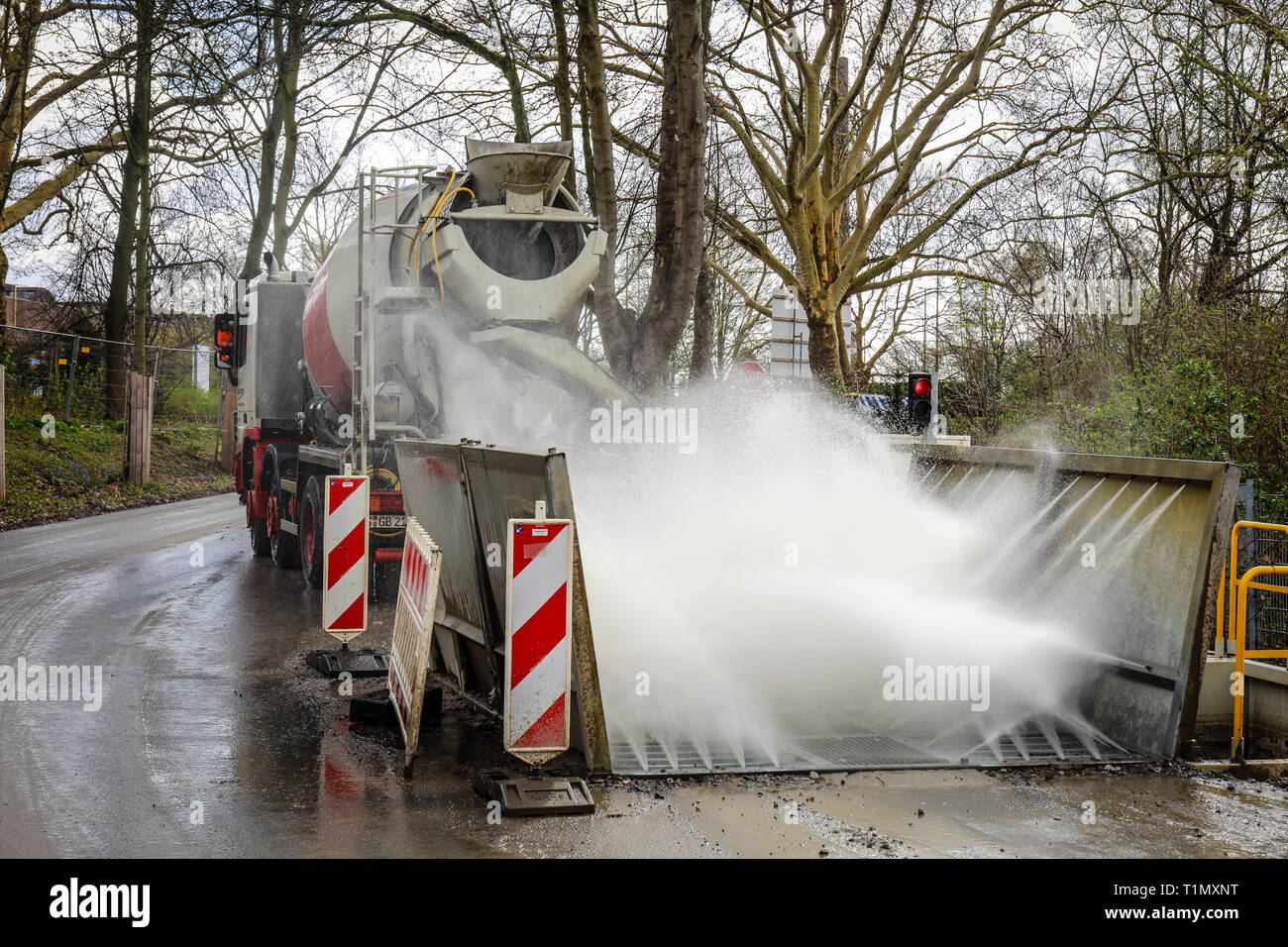 Essen, North Rhine-Westphalia, Germany - A construction site vehicle, here a concrete mixer, drives through a truck wash at a construction site exit.  Stock Photo