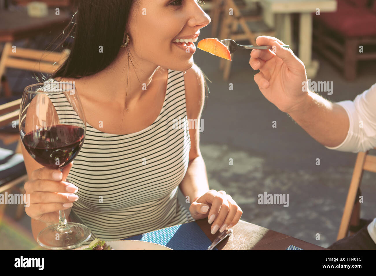 Beautiful long-haired lady carrying tall glass of red wine Stock Photo