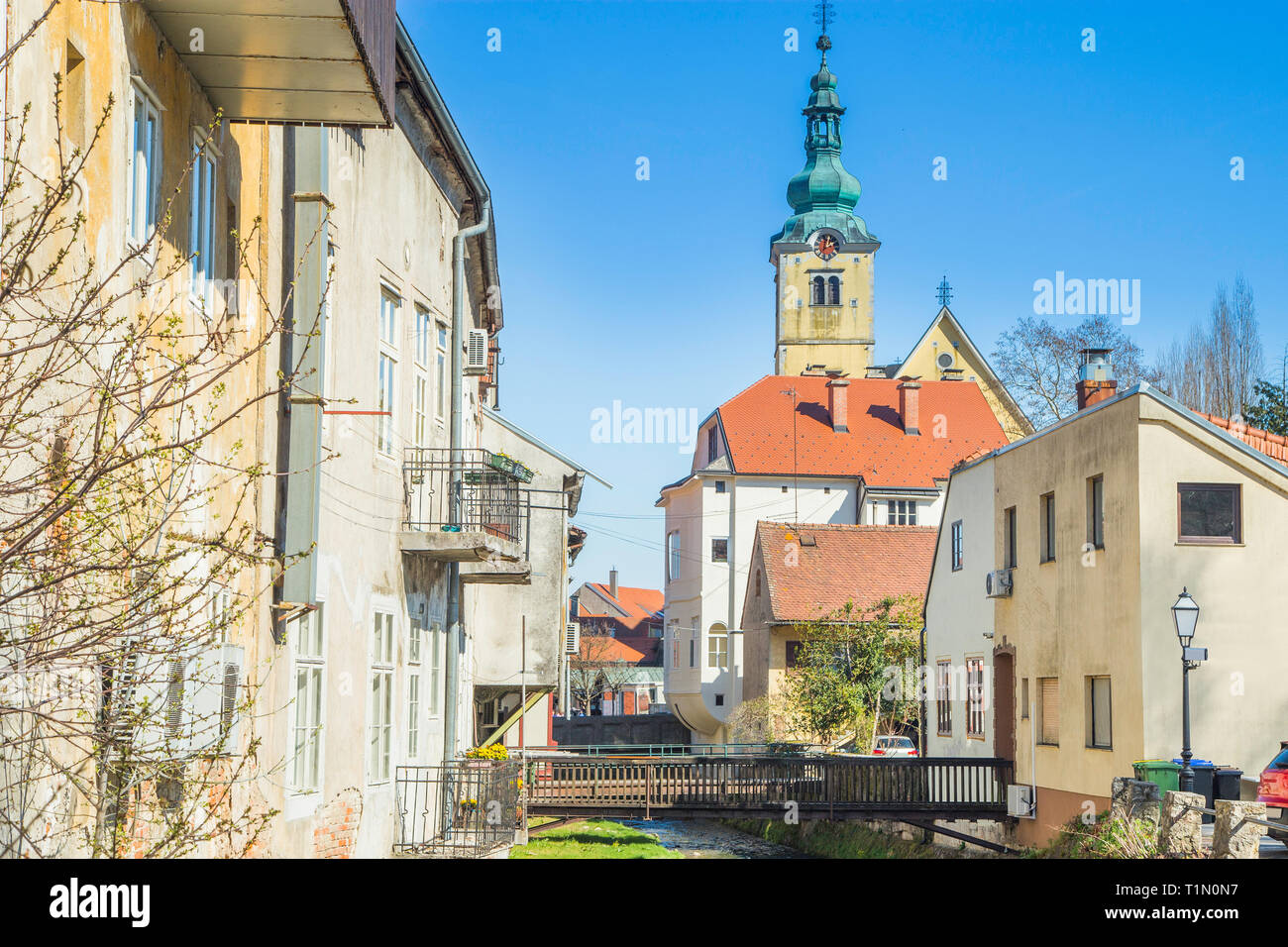 River, old wooden bridges between houses and church in background in town of Samobor in Croatia Stock Photo