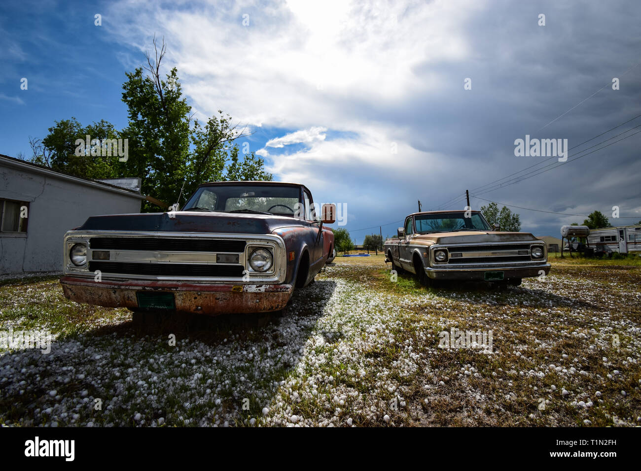 Old pickup trucks with no wheels and a backyard In Colorado Stock Photo