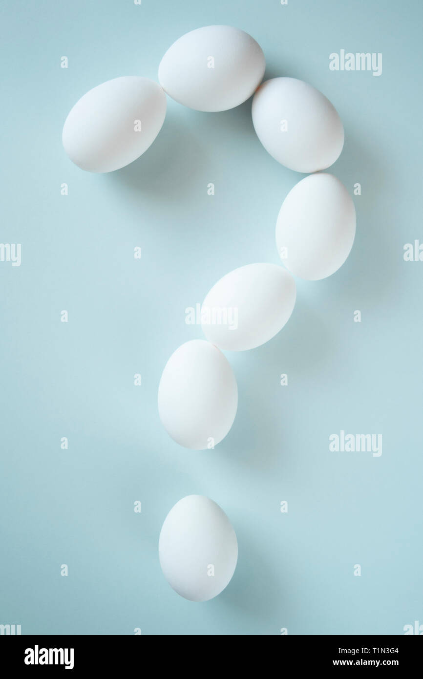 Question mark folded from white eggs on bright background. Conceptual