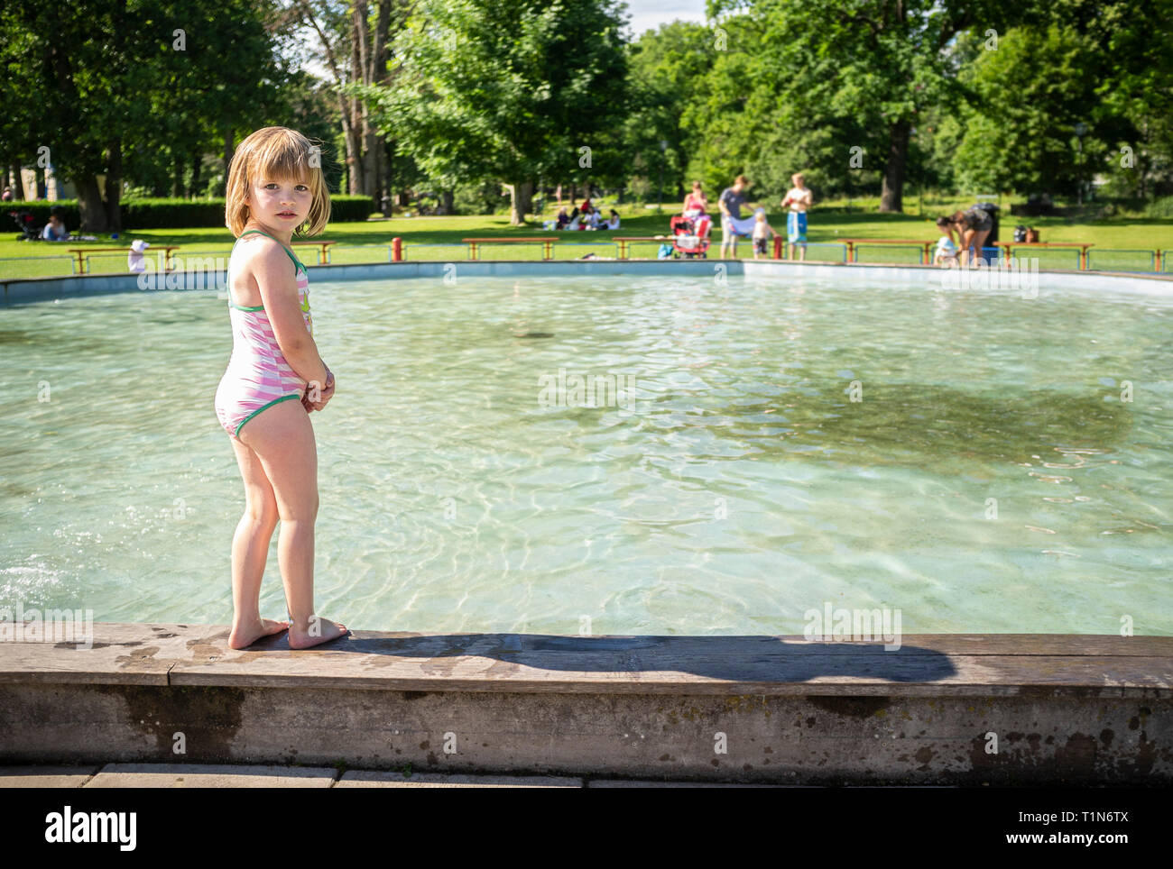 5 year old girl bathing in a swimming pool outdoors in the summer. Stock Photo