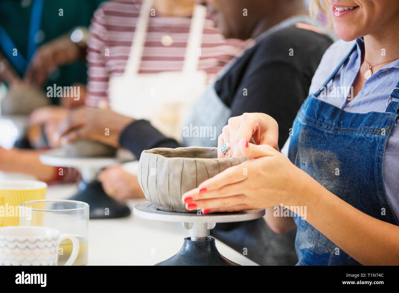 Woman making bowl in pottery class Stock Photo