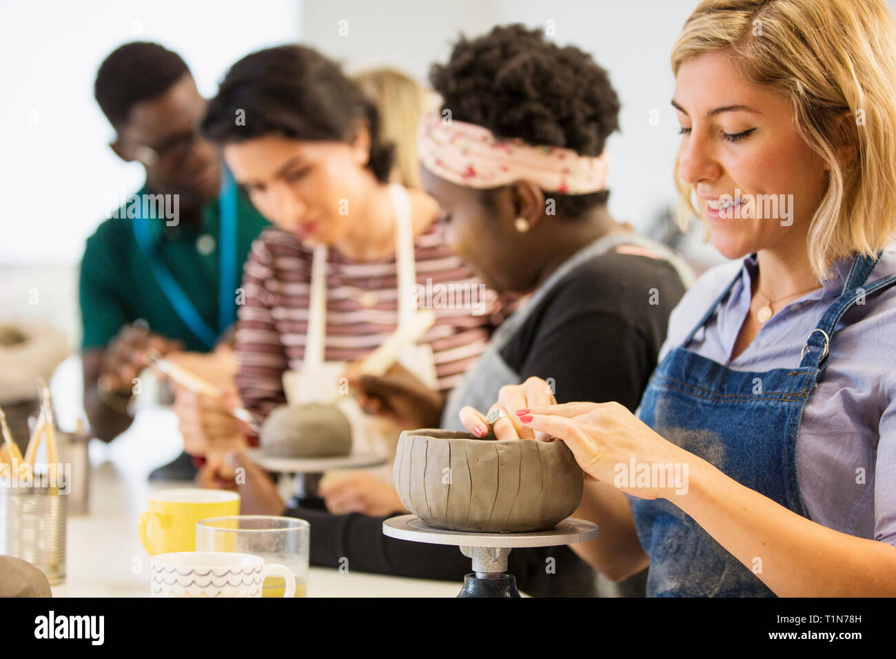 Woman making clay bowl in art class Stock Photo