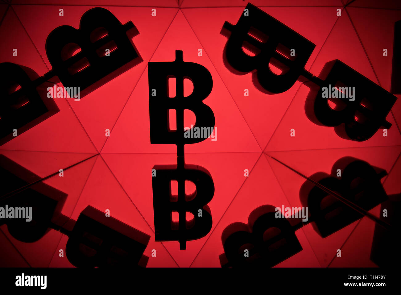 Bitcoin Currency Symbol With Many Mirroring Images of Itself on Red Background Stock Photo