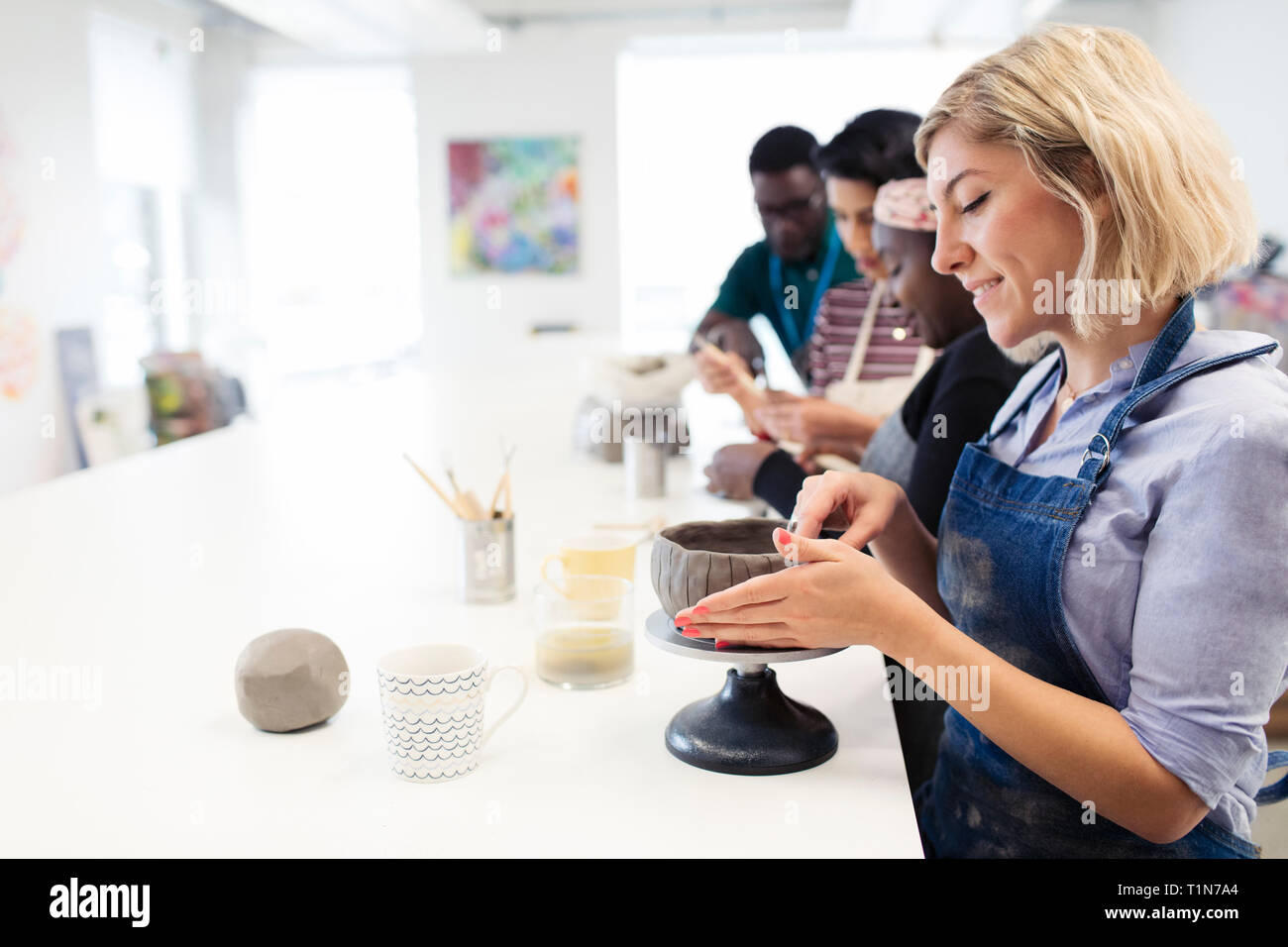 Woman making clay bowl in art class Stock Photo