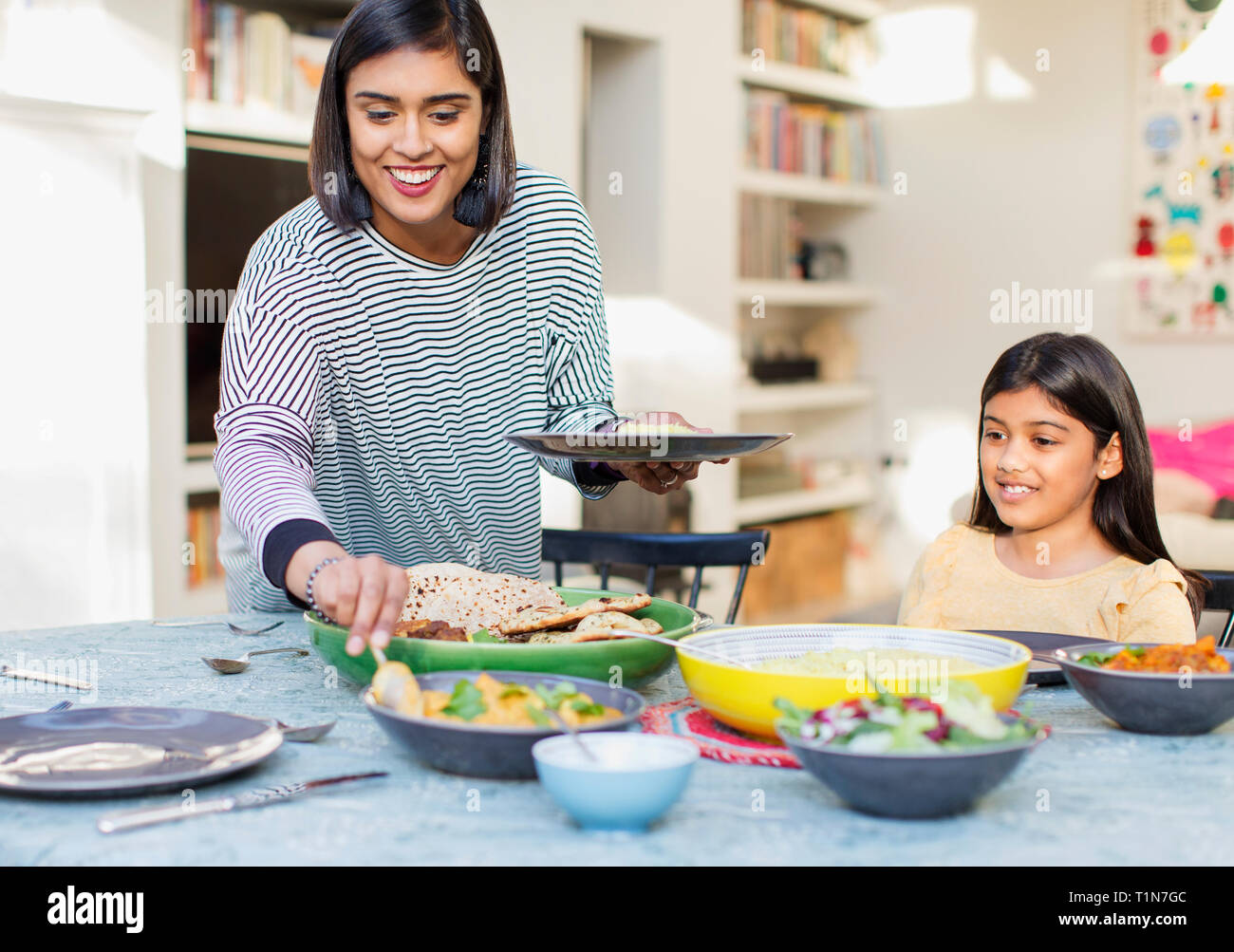 Mother serving dinner to family at dining table Stock Photo