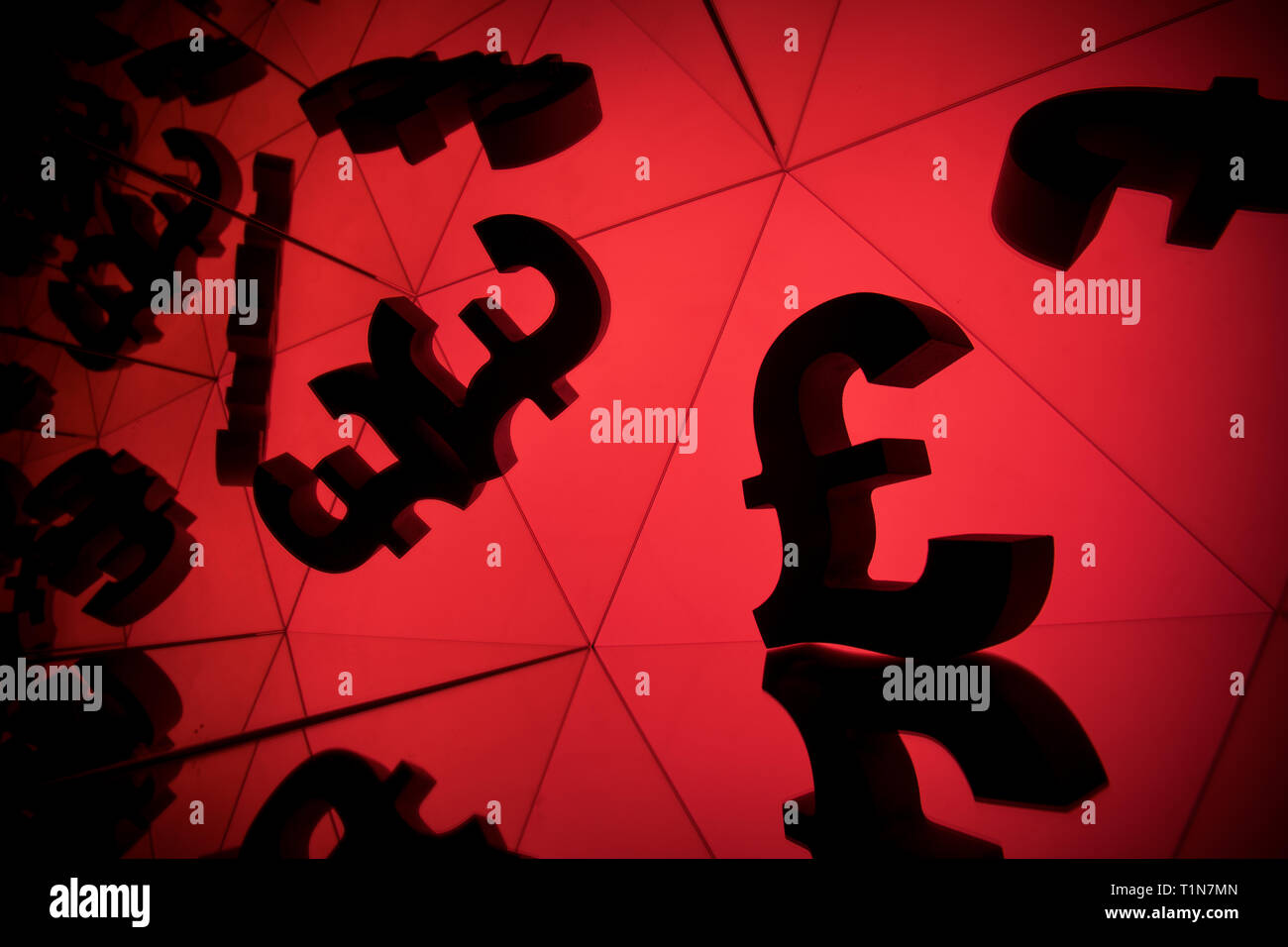 British Pound Sterling Currency Symbol With Many Mirroring Images of Itself on Red Background Stock Photo