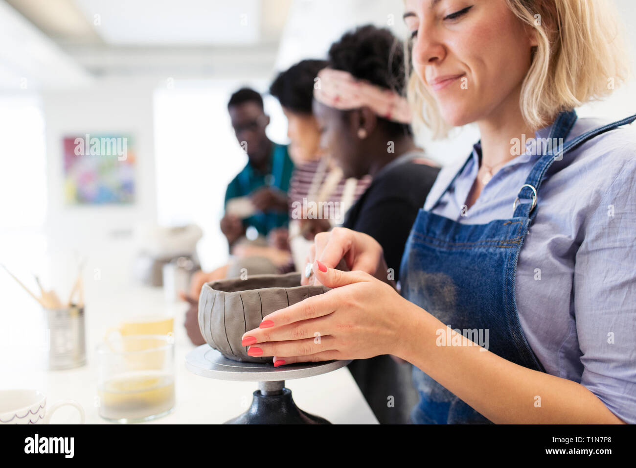 Woman shaping clay bowl in art class Stock Photo