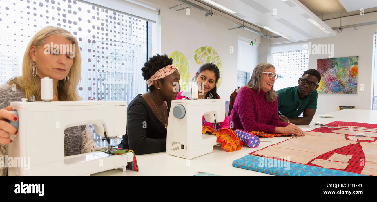 Fashion designers working at sewing machines in studio Stock Photo Alamy