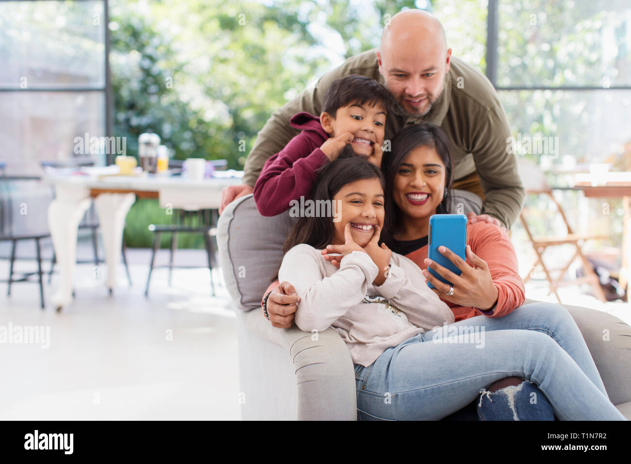 Playful family taking selfie with camera phone Stock Photo