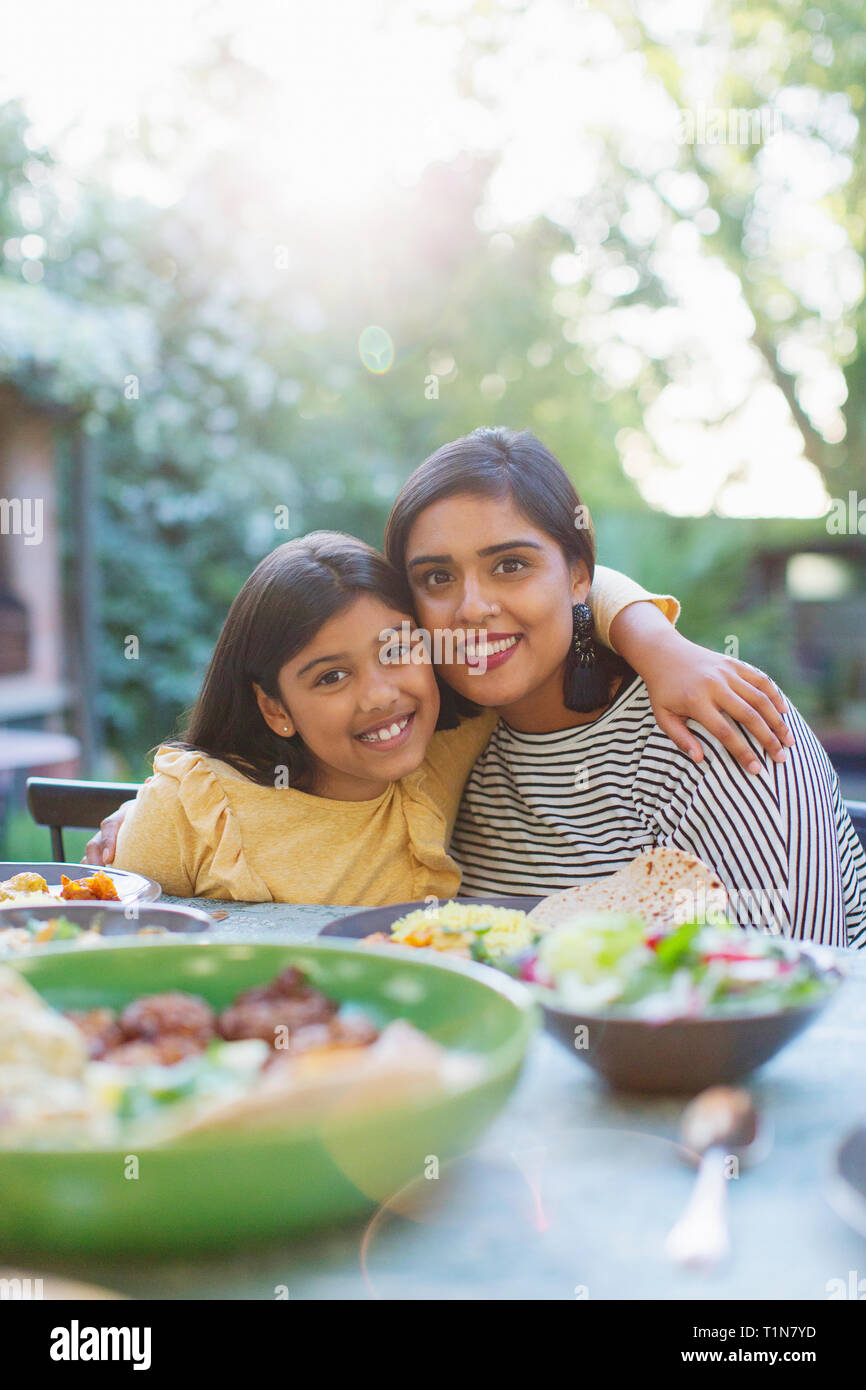 Portrait happy mother an daughter at dinner table Stock Photo