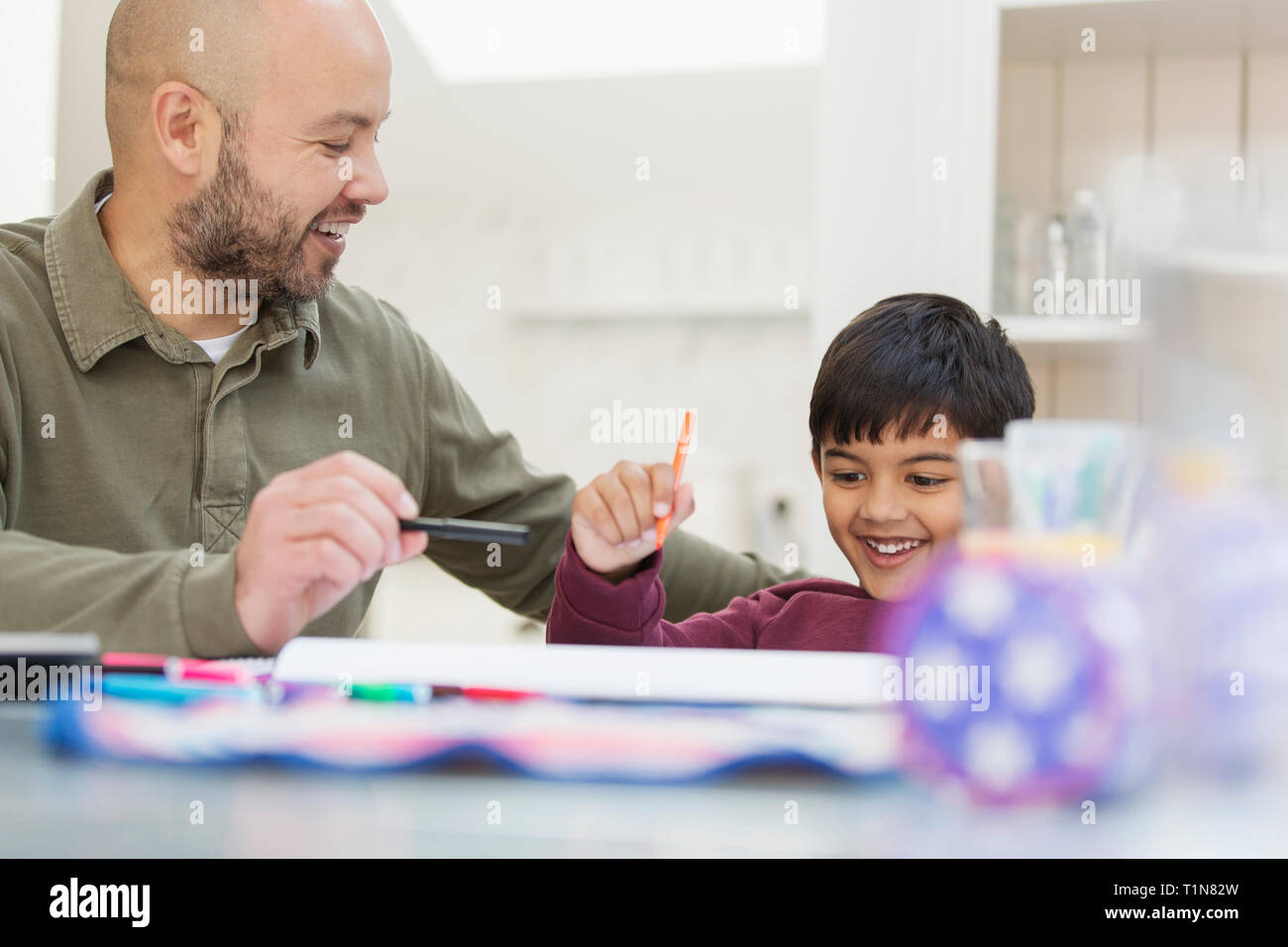 Father and son coloring at table Stock Photo