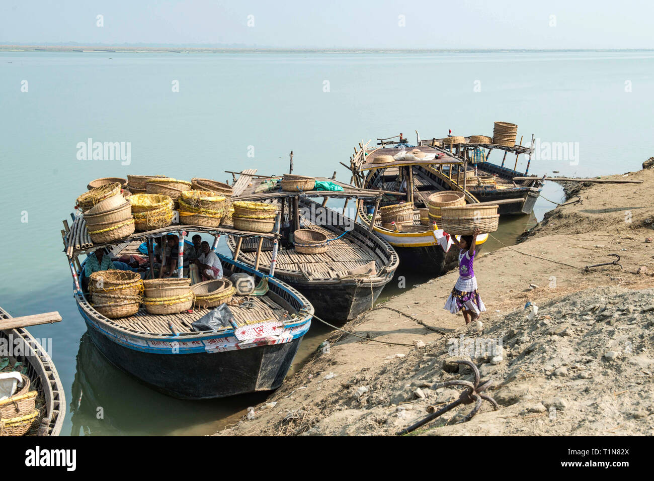INDIA, BIHAR, RAJMAHAL,Small barges being loaded with baskets for transportation to a market along the river Ganges Stock Photo